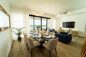 uma sala de jantar e sala de estar com mesa e cadeiras em Scenic View Apartment in Downtown Punta Cana em Punta Cana