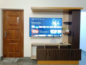 a living room with a large tv on a wall at Casa Royal HomeStay in Kattappana +16 photos