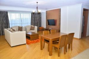 a living room with a table and a couch at Relax on the high-end space in Nairobi