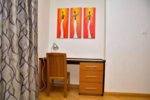 a desk with a chair and a painting on the wall at Relax on the high-end space in Nairobi +2 photos