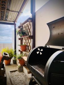 a grill sitting on a patio with potted plants at Cozy PH Apartment in the City in Guatemala