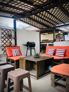 a room with orange furniture and a table and chairs at Cozy PH Apartment in the City in Guatemala