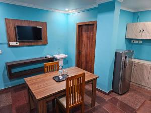 ein Esszimmer mit einem Holztisch und einem Kühlschrank in der Unterkunft Hamsted in Kottakkal