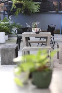 einen Tisch und Stühle auf einer Terrasse mit Pflanzen in der Unterkunft Blu Monkey Hub & Hotel Surat Thani in Surat Thani