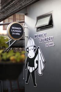 Un cartel con un mono lavando ropa colgado en la pared. en Blu Monkey Hub & Hotel Surat Thani, en Suratthani