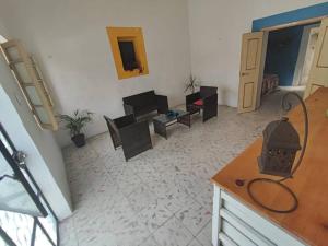ein Wohnzimmer mit einem Sofa und einem Tisch in der Unterkunft Pequeña casa en el centro de Mérida in Azcorra