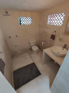 a bathroom with a toilet and a sink at Pequeña casa en el centro de Mérida in Azcorra