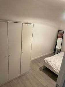 um quarto com armários brancos e uma cama em one bedroom flat near Vauxhall train station London em Londres