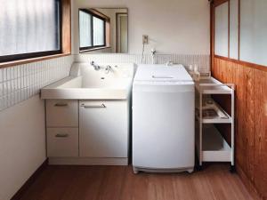 a bathroom with a sink and a washing machine at ひねもす101:宇野駅から車で5分 直島へ 最大8名様 古民家 in Tamano
