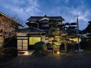 ein Haus mit einem Baum davor in der Unterkunft ひねもす101:宇野駅から車で5分 直島へ 最大8名様 古民家 in Tamano