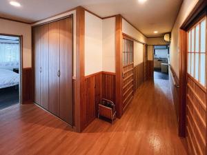 a room with wooden walls and a bedroom with a bed at ひねもす101:宇野駅から車で5分 直島へ 最大8名様 古民家 in Tamano
