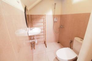 une salle de bain avec un lavabo et des toilettes dans l'établissement Omah Jombor Homestay Jogja, à Kejayan