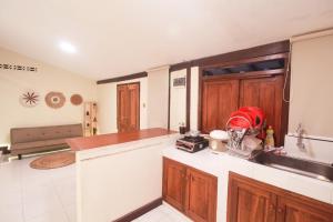 une cuisine avec des armoires en bois et un comptoir dans l'établissement Omah Jombor Homestay Jogja, à Kejayan