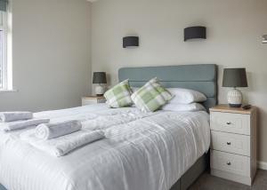 a bedroom with a large white bed with towels on it at Lee Valley in Hoddesdon