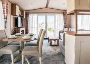 a kitchen and living room with a table and chairs at Golden Palm Resort in Chapel Saint Leonards