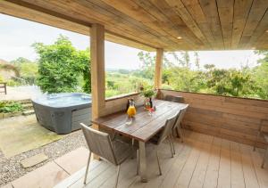 a patio with a table and a bath tub at Davis Gate Farmhouse in Ribchester