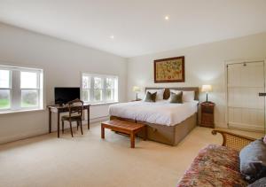 een hotelkamer met een bed, een bureau en een bank bij Davis Gate Farmhouse in Ribchester
