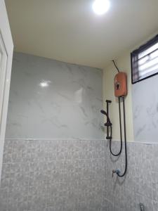 a shower in a bathroom with white marble walls at HOME NO 3 khanom in Ban Thung O
