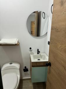 een badkamer met een toilet, een wastafel en een spiegel bij Hotel Belalcazar Palmira in Palmira