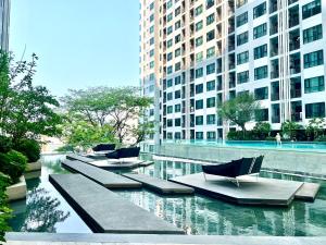 a group of chairs sitting in the water with buildings at Sea view Pattaya beach @The Base Central Pattaya in Pattaya Central