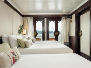 two white beds in a room with a window at The Au Co Cruise - Managed by Bhaya Cruise in Ha Long