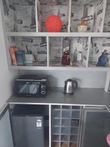 a kitchen with a stove and a tea pot on a shelf at Terrace abode in Mangalore