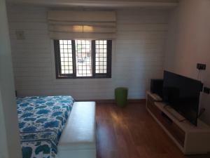 a bedroom with a bed and a flat screen tv at Terrace abode in Mangalore