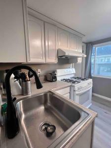 a kitchen with a sink and a stove at Charming Victorian Vacation Rental - Walking Distance BART in Oakland