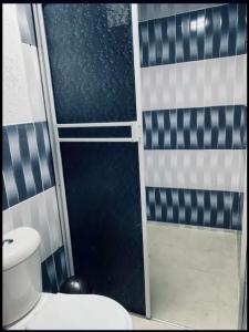baño con aseo y puerta de ducha de cristal en HOTEL RM en Nuquí
