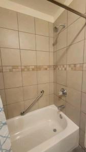 a white bath tub in a tiled bathroom at Chateau de Woodlawn - Room I - La Tour Eiffel in Chicago