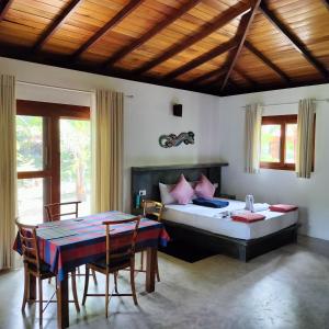 a bedroom with a bed and a table and chairs at Avalon Village Resort in Induruwa