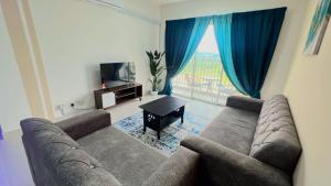 a living room with a couch and a large window at JC Homestay Gamuda SkyLuge KL 1 in Rawang