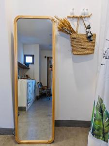 a mirror in a hallway with a wicker basket at VYA homestay Huế in Thôn Lại Thê