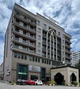 un gran edificio con coches estacionados frente a él en Puteri Bay Hotel, en Melaka