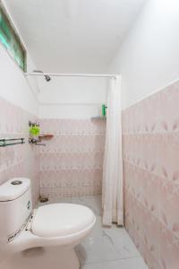 a pink bathroom with a toilet and a shower at Mystique abode in New Delhi