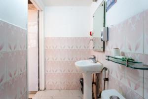 uma casa de banho rosa com um lavatório e um espelho em Mystique abode em Nova Deli mais 15 fotografias