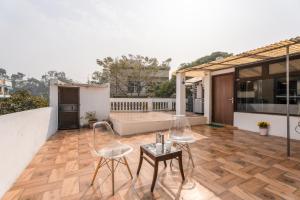 a patio with two chairs and a table on a house at Mystique abode in New Delhi