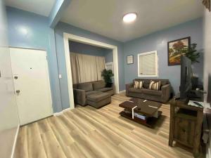 uma sala de estar com um sofá e uma televisão em Victorian Oasis: Charm & Convenience Near Lake Merritt em Oakland