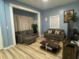 uma sala de estar com um sofá e uma televisão em Victorian Oasis: Charm & Convenience Near Lake Merritt em Oakland