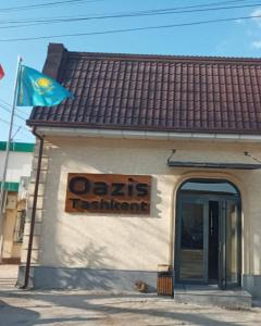 un chien assis à l'extérieur d'un restaurant avec drapeau dans l'établissement OA Tashkent, à Qŭyliq