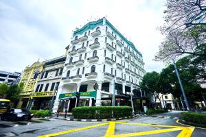 a white building on the corner of a street at Cojoy Hotel @ Chinatown in Kuala Lumpur