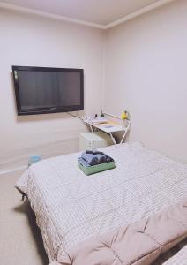 Taereung stay في سول: غرفة نوم بسرير وتلفزيون بشاشة مسطحة