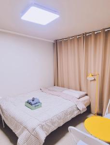una camera da letto con un letto con una valigia sopra di Taereung stay a Seul