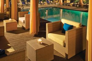 a pool with chairs and tables next to a swimming pool at Los Angeles Marriott Burbank Airport in Burbank