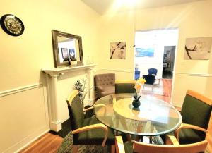 a dining room with a glass table and chairs at Chateau de Woodlawn - Room III - The Dream Catcher in Chicago