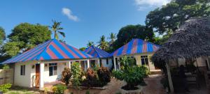 a row of houses with red and blue roofs at Usumba Lodge in Chejuu