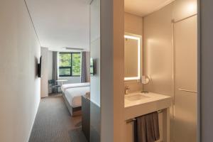 a bathroom with a sink and a bed in a room at Urbanstay Busan songdo Beach in Busan