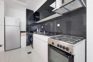 a white kitchen with a stove and a refrigerator at Primestay - Park Central Studio - Business Bay in Dubai