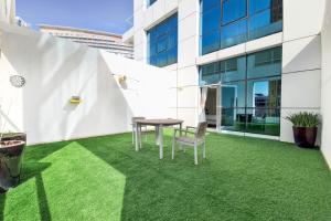a patio with grass and a table and chairs at Primestay - Park Central Studio - Business Bay in Dubai