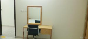 a desk with a mirror and a chair in front at فندق رفال الغربية للشقق المخدومة in Ukaz
